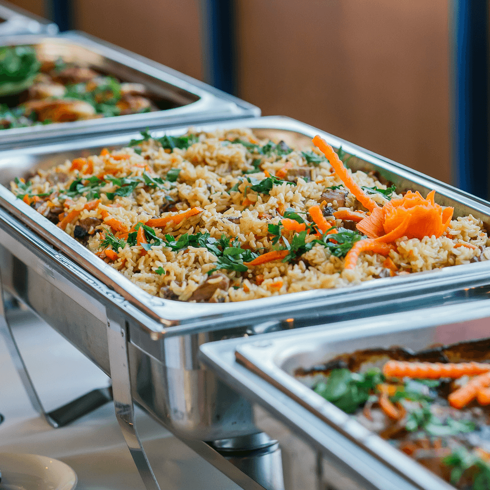 A buffet tray filled with fragrant rice, carrots, and parsley garnishes.