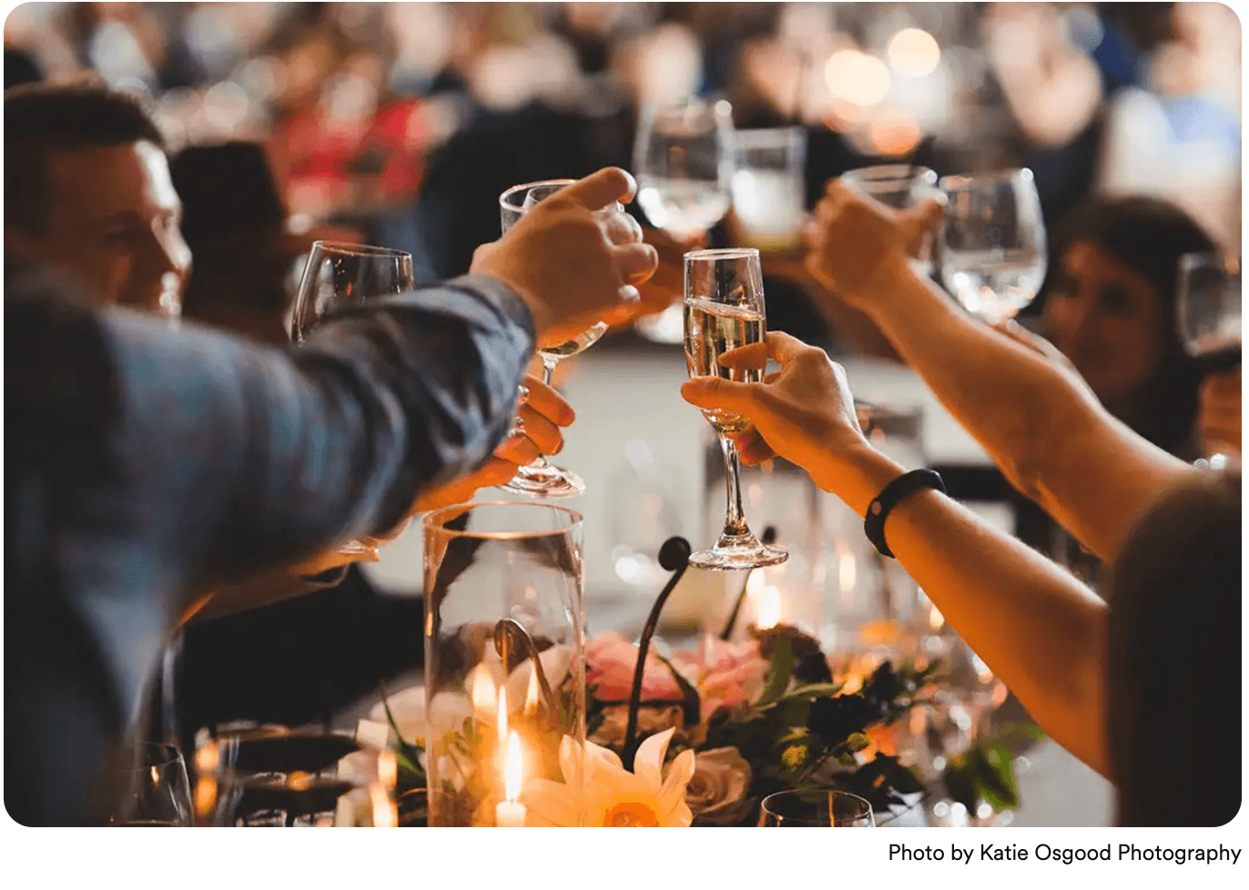 A group of people toasting with glasses at a celebratory event. A group of people toasting with glasses at a celebratory event.